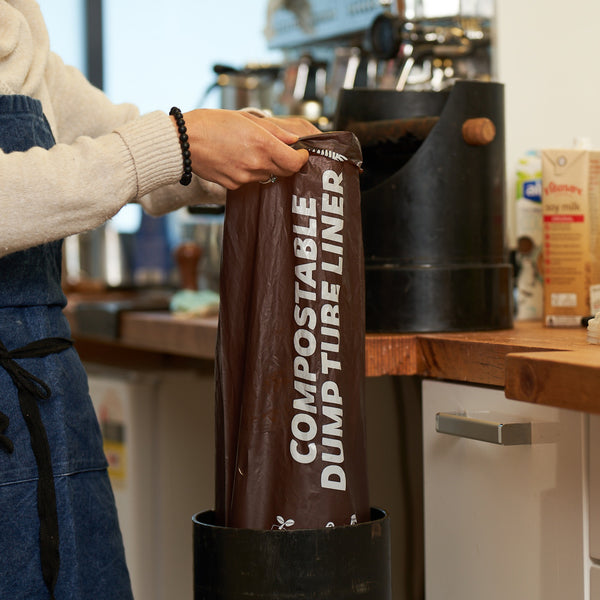 Compostable coffee dump tube liner for cafe's. Picture of liner being used.